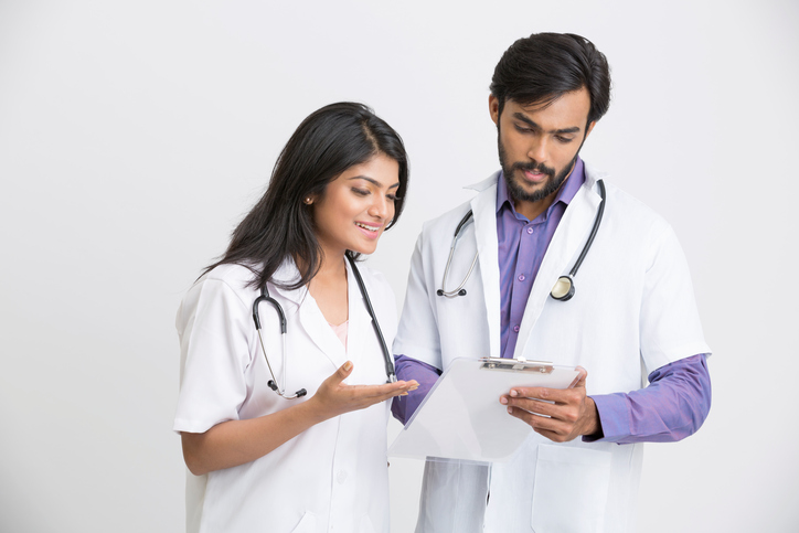 Two young Indian attractive doctors on white background